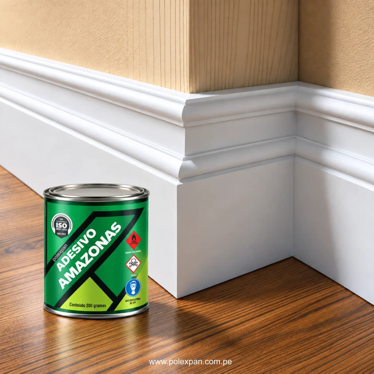 Zócalo blanco con moldura al pie de una pared, sobre piso de madera; delante, la lata de adhesivo Amazonas rotulada «Conteúdo 200 gramas» y «Uso obrigatório de EPI».